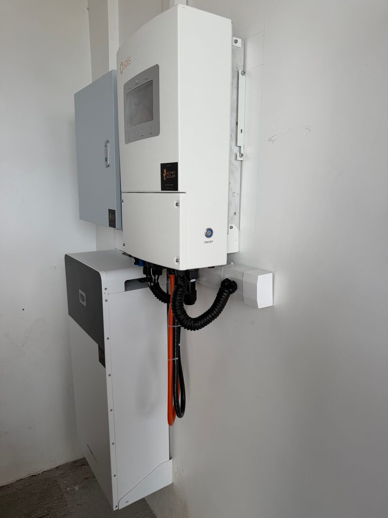 Close view of the inverter and protection box, battery cable looped below.